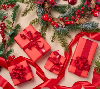Noel dekoru, kırmızı kağıda sarılı hediyeler bej arka plan, üst manzara