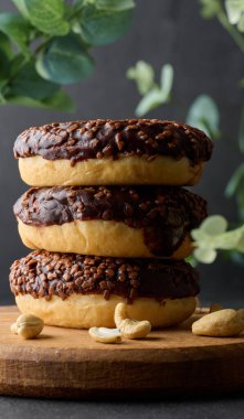 Çikolatalı çörekler siyah masaya ezilmiş fındıklar serpiştirilmiş.