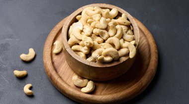 Masanın üzerinde bir ahşap kase kaju fıstığı