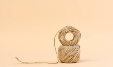 Skein of brown thread on a beige background clipart