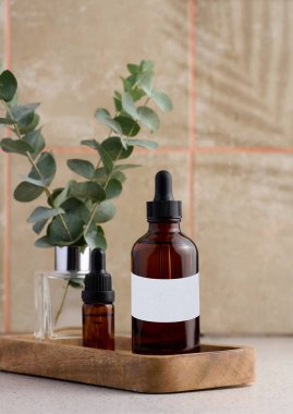 Üzerinde beyaz etiket ve pipet olan kahverengi cam şişe, kozmetik ürünleri için konteynır.