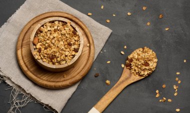 Yulaf ezmesi, kuru üzüm, kaju ve badem. Tahta tabakta granola, üst manzara.