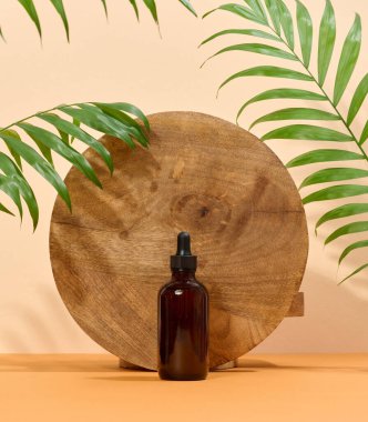 Kozmetik için cam şişe, bej arka planda pipetli yağlar.