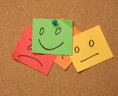 Etikette farklı duygulara sahip yüzler çizilmiş ve mantar panoya yapıştırılmış. Beğeni ve kalite değerlendirmesi