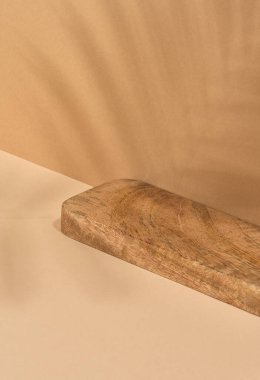 Tahta platform, kahverengi arka planda palmiye yaprağının gölgesi. Kozmetik ürünleri gösterilecek yer