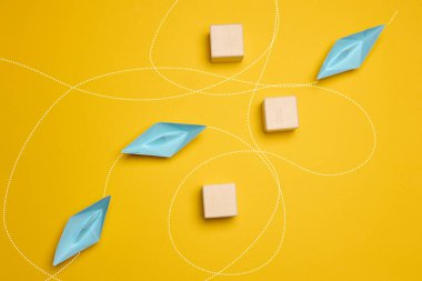 Paper boats and the trajectory of movement avoiding obstacles, yellow background clipart