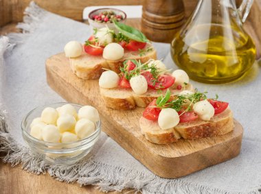 Yuvarlak mozzarella, kiraz domatesleri ve bir parça beyaz ekmek üzerine mikroyeşiller, sağlıklı bir sandviç.