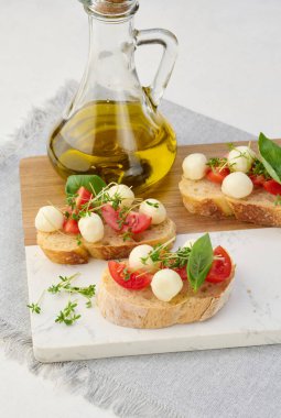 Yuvarlak mozzarella, kiraz domatesleri ve bir parça beyaz ekmeğin üstünde mikroyeşiller.