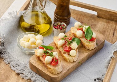 Yuvarlak mozzarella, kiraz domatesleri ve bir parça beyaz ekmek üzerine mikroyeşiller, sağlıklı bir sandviç.