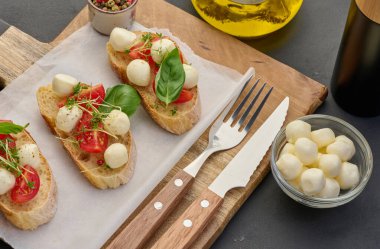 Yuvarlak mozzarella, kiraz domatesleri ve bir parça beyaz ekmek üzerine mikroyeşiller, sağlıklı bir sandviç.