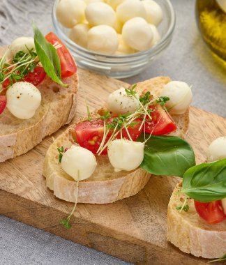 Yuvarlak mozzarella, kiraz domatesleri ve bir parça beyaz ekmek, sağlıklı bir sandviç, yakın çekim.