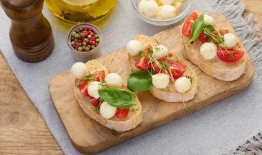 Yuvarlak mozzarella, kiraz domatesleri ve bir parça beyaz ekmek üzerine mikroyeşiller, sağlıklı bir sandviç.