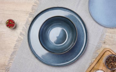 Masanın üzerinde boş mavi yuvarlak seramik tabak, üst görünüm