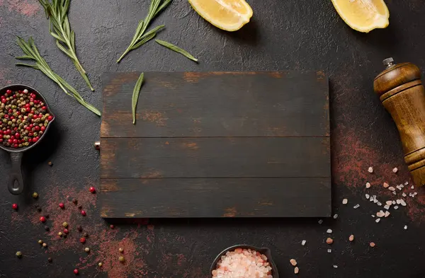 Mutfak aletleri ve baharatlarla mutfak kompozisyonu, Himalaya tuzu, renkli biberler, masada taze biberiye. Üst görünüm