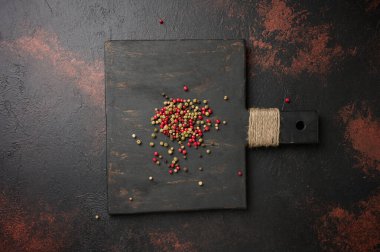 Tahta üzerinde kırmızı, yeşil ve siyah biber karışımı, üst manzara.
