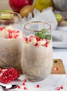 Bir bardak chia tohumu ve yoğurt, muzun parçaları ve nar tohumlarıyla tatlıya eklendi.