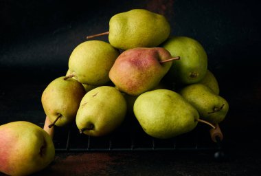 Kahverengi arka planda bir yığın yeşil armut.