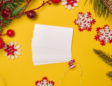 Noel süslemeleri arasında boş beyaz kağıt kartvizitler, üst görünüm