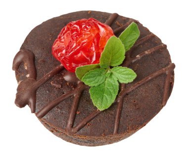 Arkaplanda nane yaprağı ve kiraz çileğiyle süslenmiş yuvarlak fırınlanmış browni parçası.