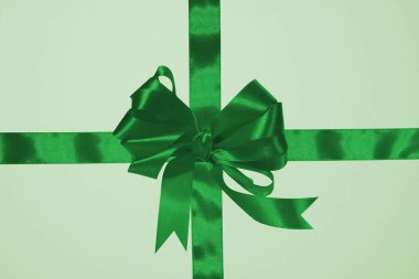 Yeşil ipek kurdele, yeşil arka planda çapraz kurdele, hediye paketi. Üst görünüm