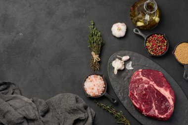 Tahtada çiğ biftekli Chuck 'ın göz yuvarlaması. Himalaya tuzu, karabiber ve kekik filizleri pişirmek için baharatlar. Boşluğu kopyala