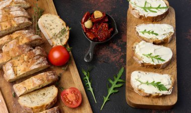 Ciabatta parçalarına sürülmüş krem peynir ve roka yapraklarıyla süslenmiş, aperatif.