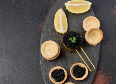 Siyah mersin balığı havyarı ve boş yuvarlak turtalar masanın üstünde. Boşluğu kopyala