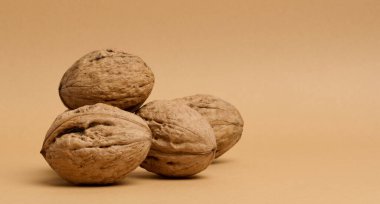 Kahverengi arkaplanda ceviz meyvesi yığını, boşluğu kopyala 