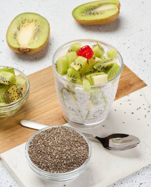 Bir bardakta yoğurt ve chia tohumu pudingi, kivi parçaları. Beyaz tablo