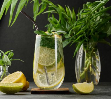 Limon, kireç, nane, buz ve metal pipetle detoks veya yaz içeceği. Koyu arkaplan