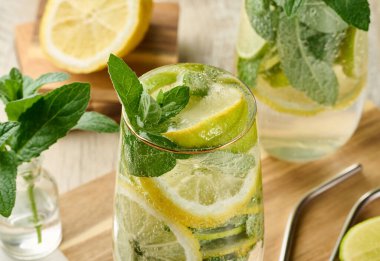 Buz, limon, limon ve nane yapraklarıyla narenciye ve nane likörü serinletici bardaklarda. Sağlıklı yaz içeceği