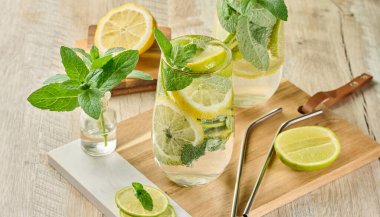 Buz, limon, limon ve nane yapraklarıyla narenciye ve nane likörü serinletici bardaklarda. Sağlıklı yaz içeceği