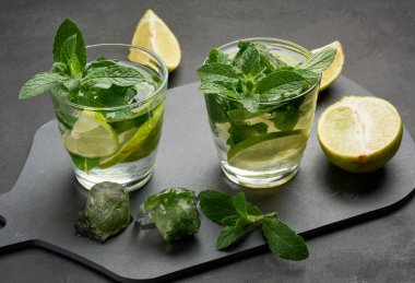 Mojito kokteylini limon, nane ve buzlu koyu arka planda yenileyeceğiz.