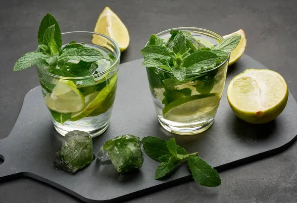 Mojito kokteylini limon, nane ve buzlu koyu arka planda yenileyeceğiz.