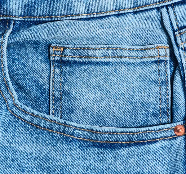 Kapalı kot pantolonun ön cebinde belirgin turuncu dikişler var.