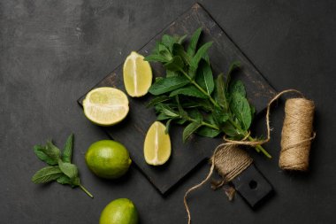 Tahta tahtada taze yeşil nane ve kireç parçaları var.