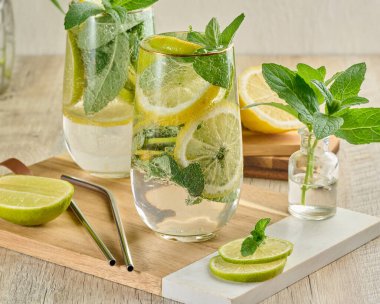 Buz, limon, limon ve nane yapraklarıyla narenciye ve nane likörü serinletici bardaklarda. Sağlıklı yaz içeceği