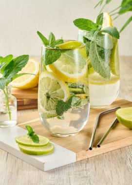 Buz, limon, limon ve nane yapraklarıyla narenciye ve nane likörü serinletici bardaklarda. Sağlıklı yaz içeceği