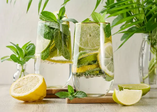 Buz, limon, limon ve nane yapraklarıyla narenciye ve nane likörü serinletici bardaklarda. Sağlıklı yaz içeceği