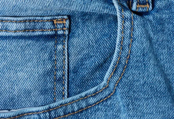 Kapalı kot pantolonun ön cebinde belirgin turuncu dikişler var.