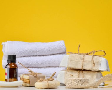 Spa ve doğal kozmetik ürünleri, beyaz havlular, el yapımı birkaç kalıp sabun el işi ambalajlar ve sicim ve bir şişe yağ..