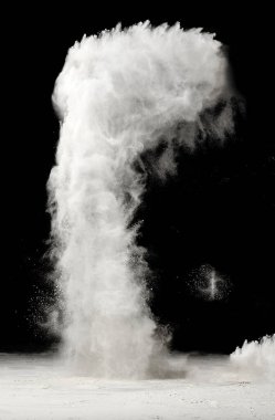 Bir beyaz un sütunu patlar ve siyah arka plana doğru yükselir. Un bir bulut oluşturur..