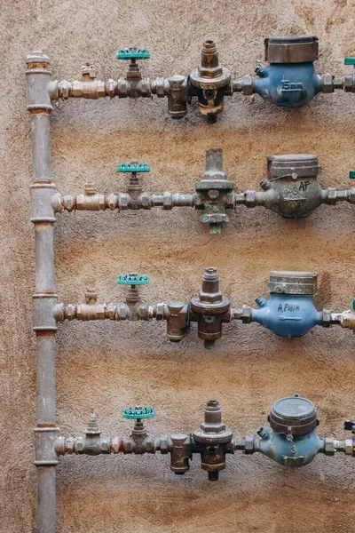 Wasserleitungen Mit Messgeräten Vor Einem Alten Haus Italien lizenzfreie Stockfotos