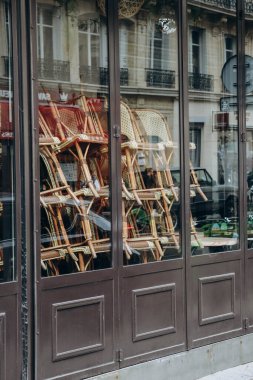 Tipik Paris hasır sandalyeleri kapalı bir restoranın pencerelerinde üst üste dizilmiş.