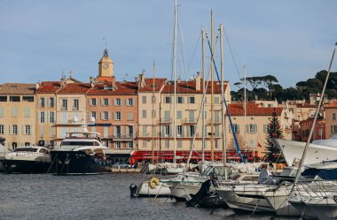 Saint-Tropez, Fransa - 28.12.2021: Güneşli bir kış gününde Saint-Tropez rıhtımının manzarası ve seti