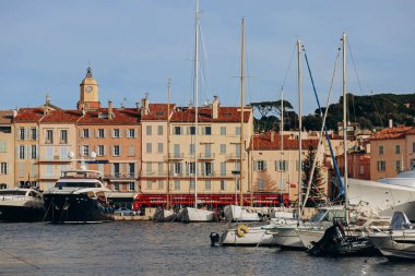 Saint-Tropez, Fransa - 28.12.2021: Güneşli bir kış gününde Saint-Tropez rıhtımının manzarası ve seti