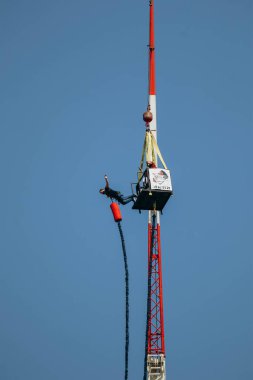 Büyük bir elastik kabloya bağlıyken yüksek bir yerden bungee jumping