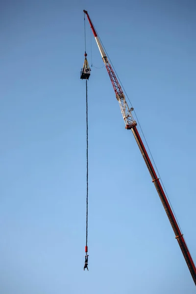 Bungee jumping from a great height while connected to a large elastic cord