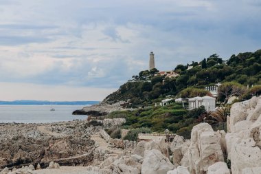 Saint Jean Cap Ferrat yarımadasındaki deniz fenerinin manzarası bulutlu havada, Fransız Riviera 'sında