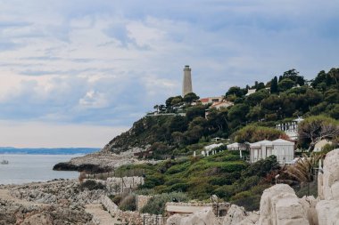 Saint Jean Cap Ferrat yarımadasındaki deniz fenerinin manzarası bulutlu havada, Fransız Riviera 'sında